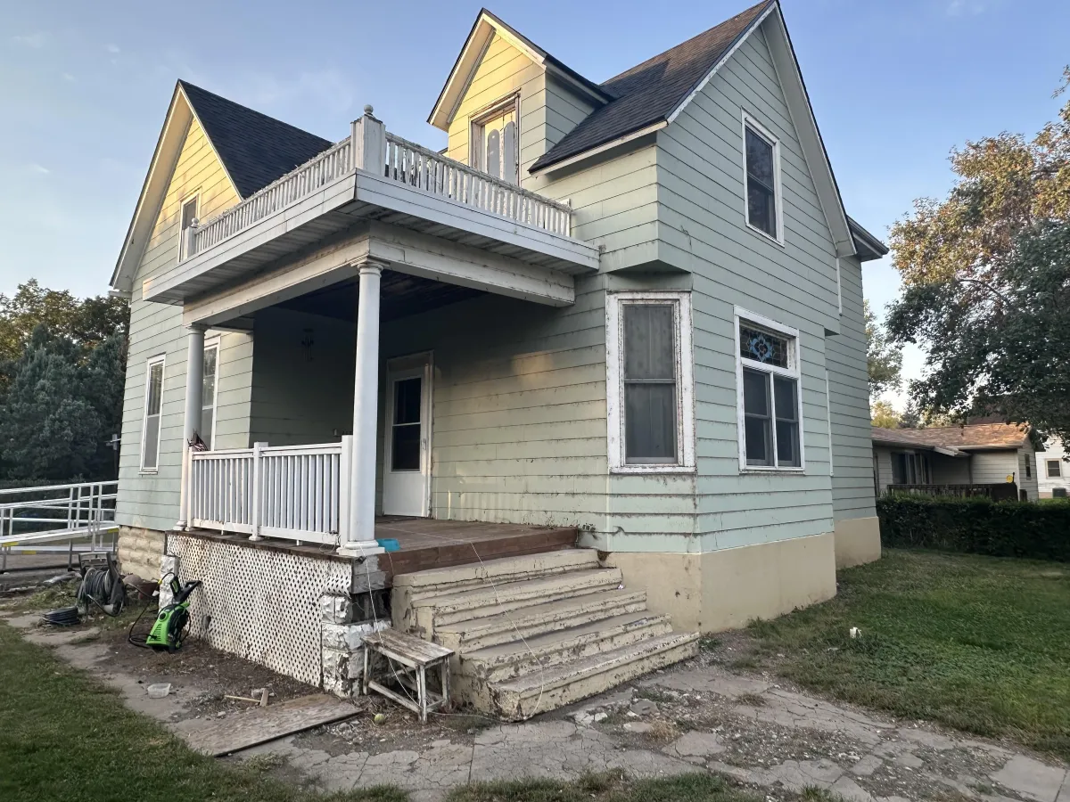 Before exterior paint: worn siding and faded trim on residential home