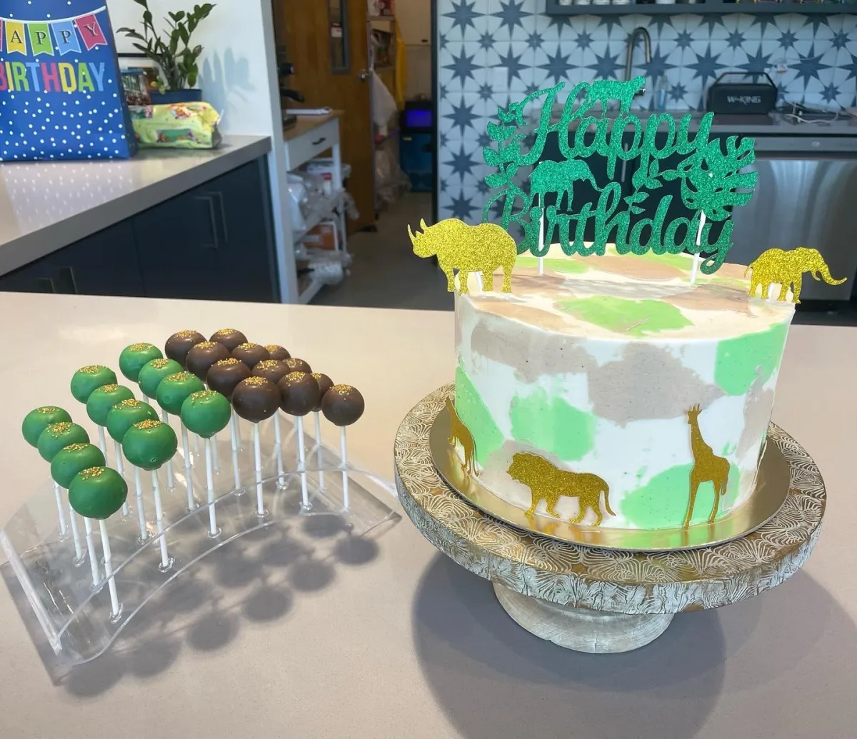 Jungle-themed birthday cake with matching animal cake pops at Wild Child indoor playground in Bastrop, TX