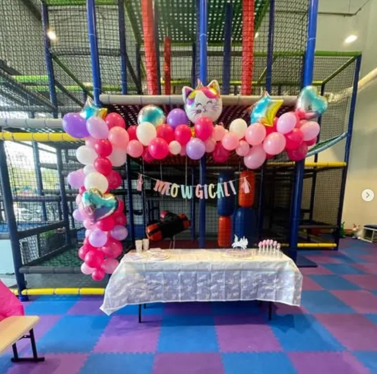 Cat-themed birthday party setup with cat balloons and matching decor at Wild Child indoor playground in Bastrop, TX