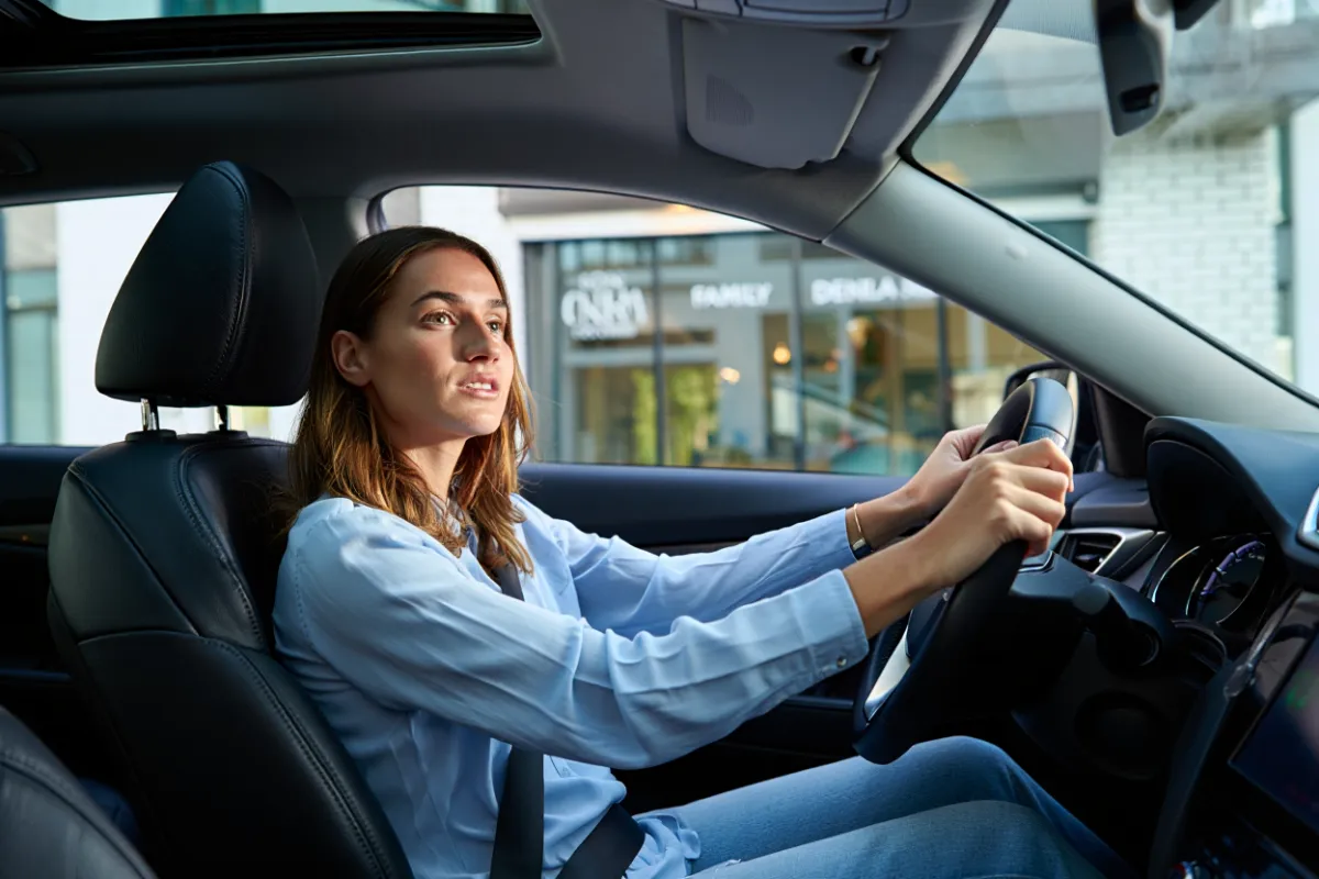 Woman driving away from the dentist office after a procedure
