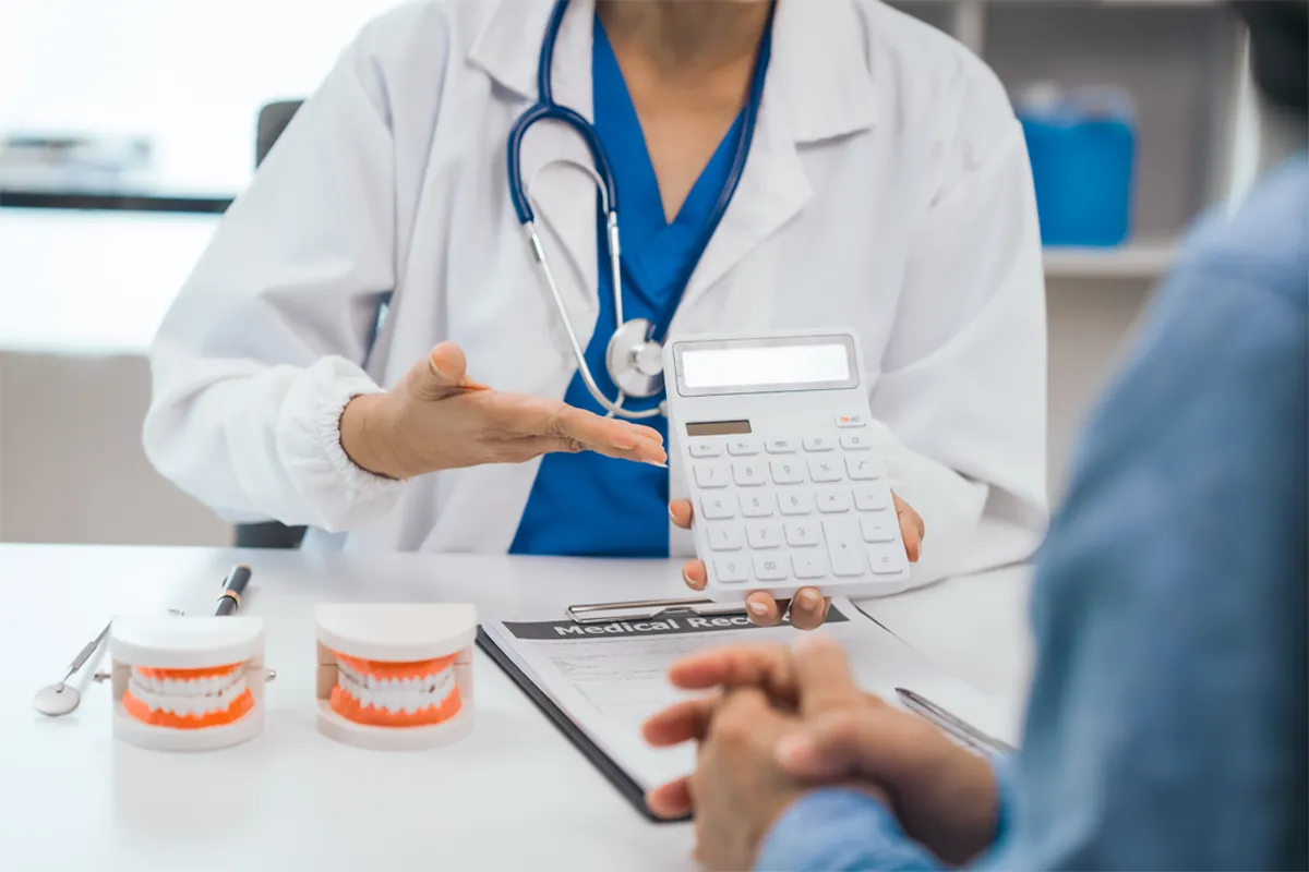 Dental Patient Treatment Case being presented by a dentist holding a calculator to a patient