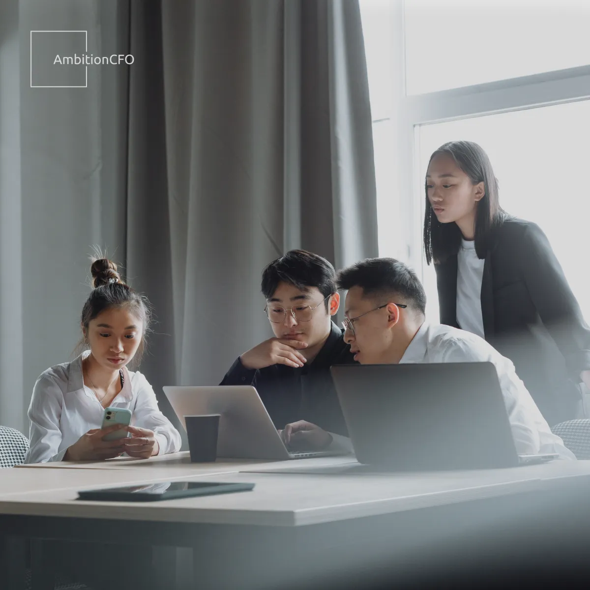 Professional business team reviewing financial reports during a merger meeting, guided by a Fractional CFO
