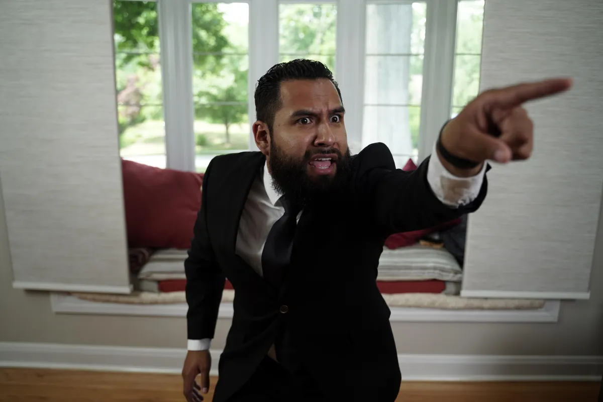 A young entrepreneur in a suit and tie pointing straight ahead