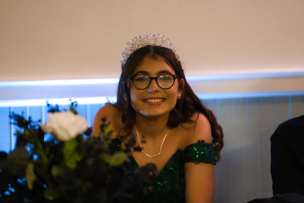 Quinceañera portrait of a 15-year-old girl in a green dress with a crown, capturing her elegance.
