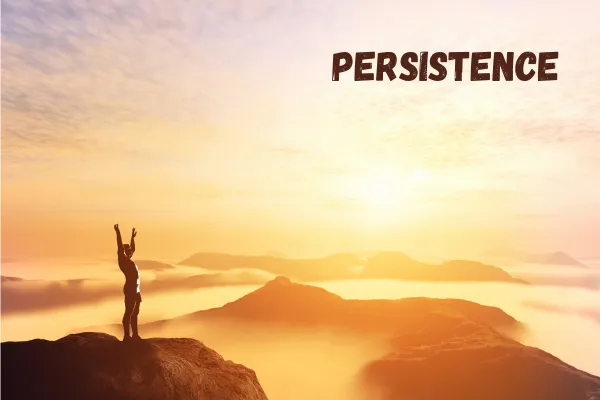 A man standing victorious on top of a mountain
