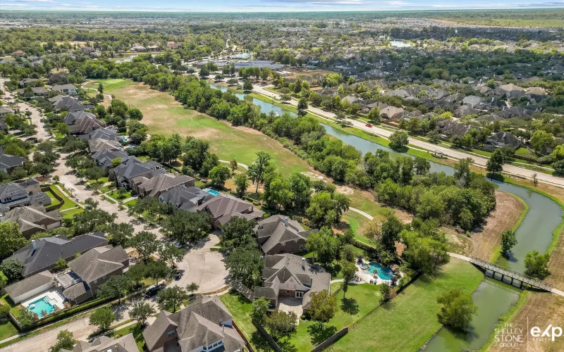 An aerial view of a picturesque neighborhood in Fort Bend County, showcasing the scenic layout and lush greenery of the area.