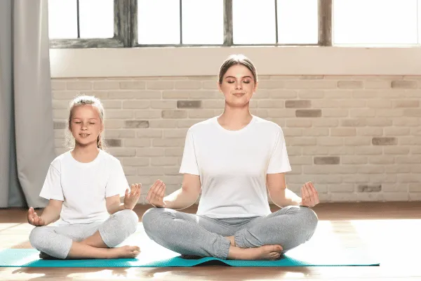 Girl doing yoga with her mom