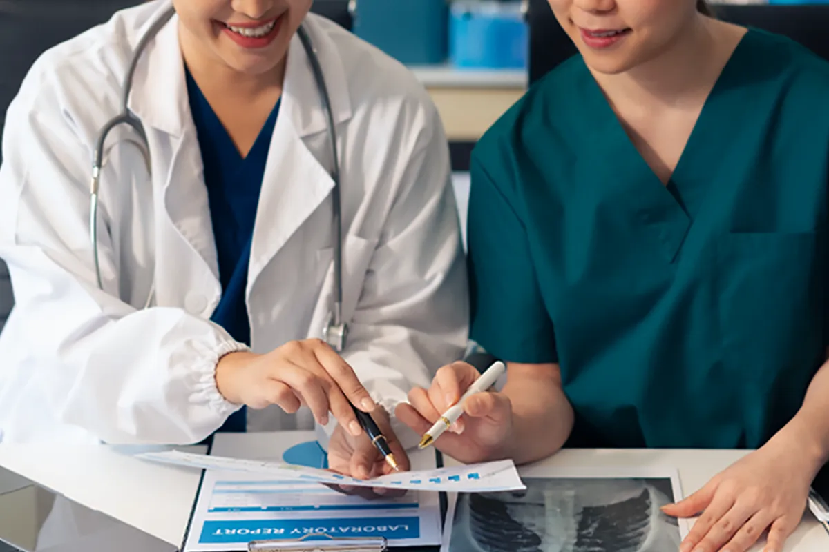 Dentist with her assistant going over how to join multiple dental insurance networks