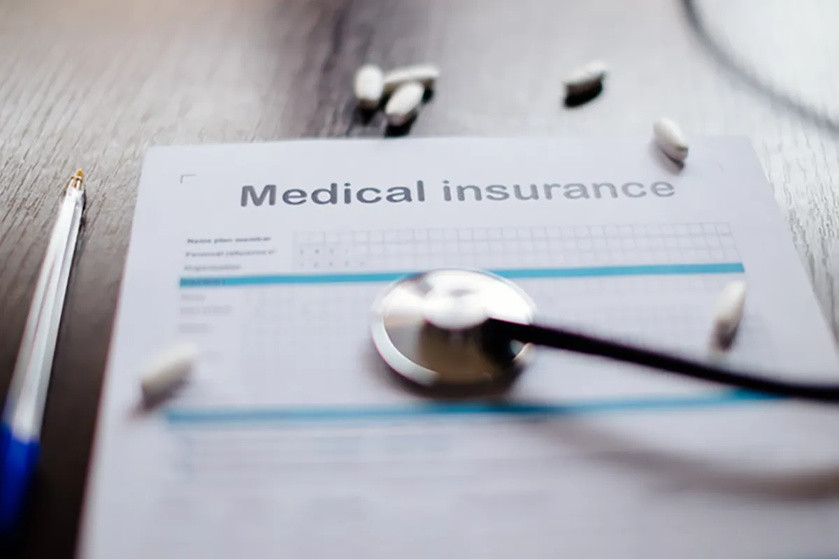Closeup of a medical insurance application on a desk with a stethoscope