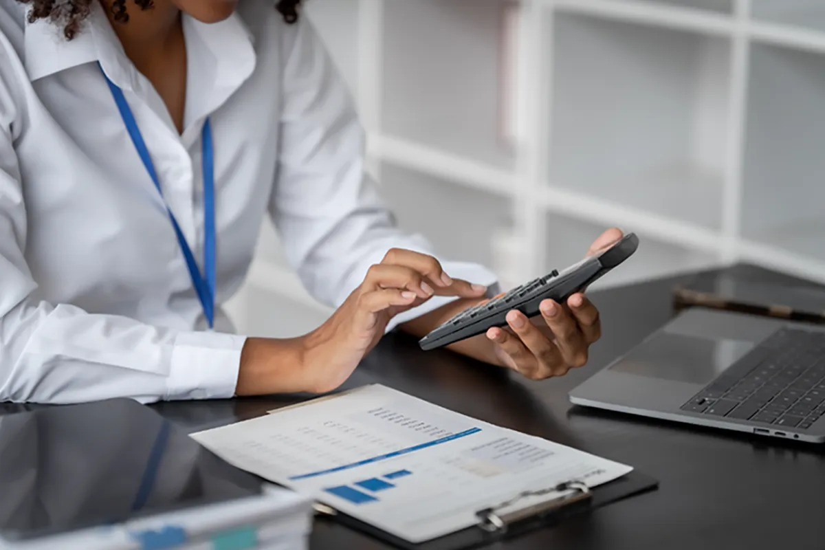  Dentist doing paperwork and holding a calculator checking financials