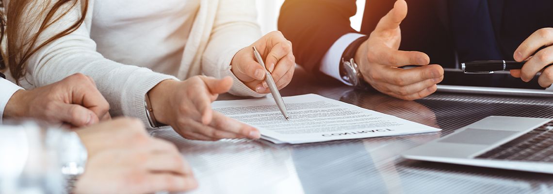 3 personnes dont on ne voit que les mains discutent sur le sujet d'un contrat. Image crée par IA