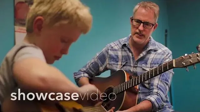 Kyle the owner working with a young guitar student