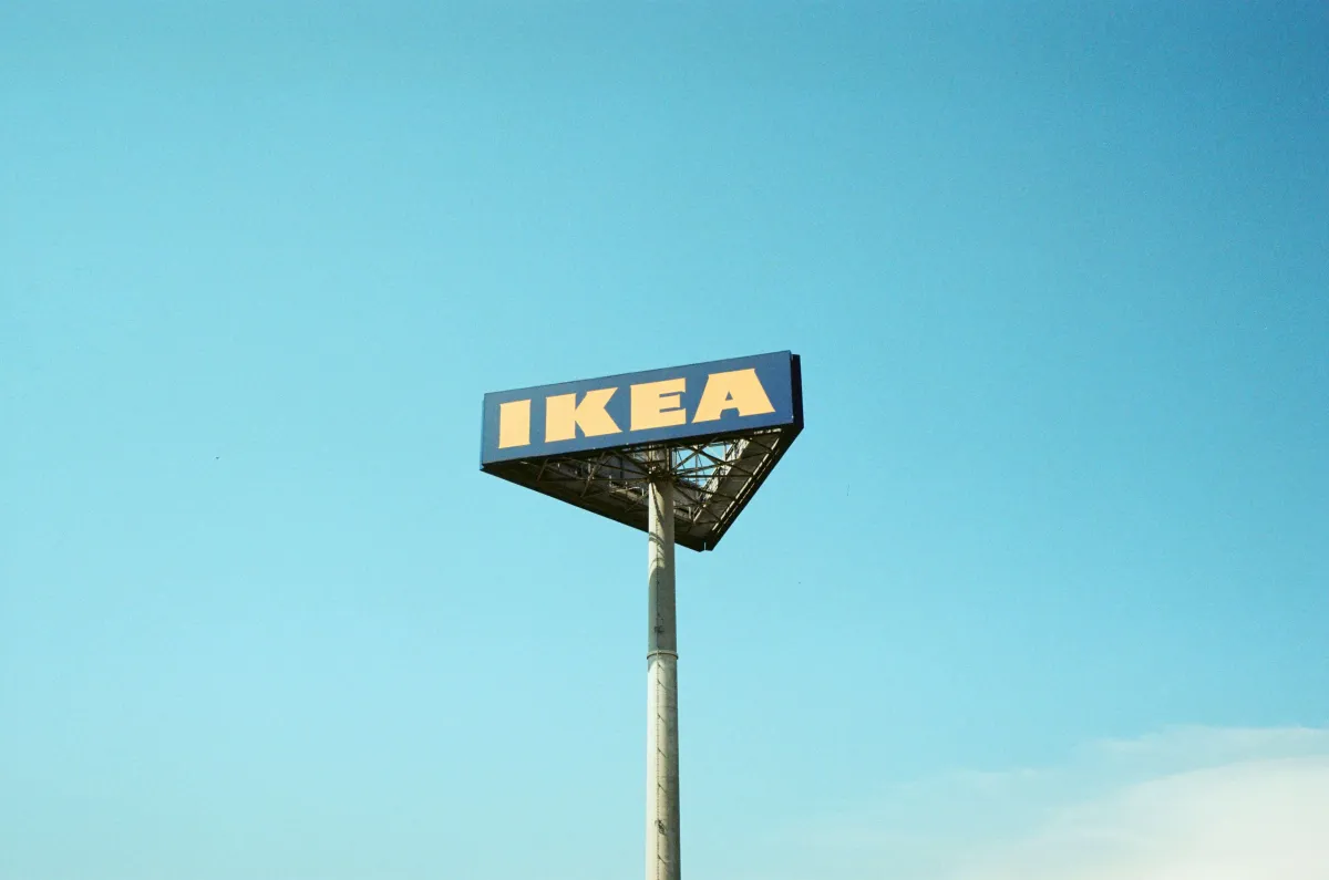 An elevated IKEA sign against a blue sky.