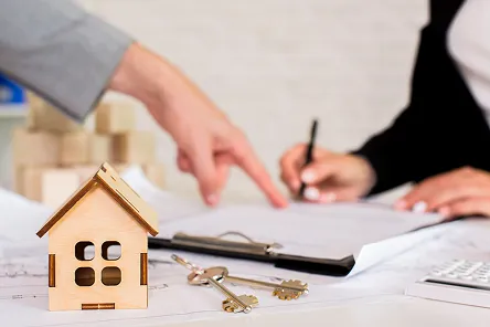 Homme confiant tenant des clés devant sa nouvelle propriété après un premier investissement immobilier réussi
