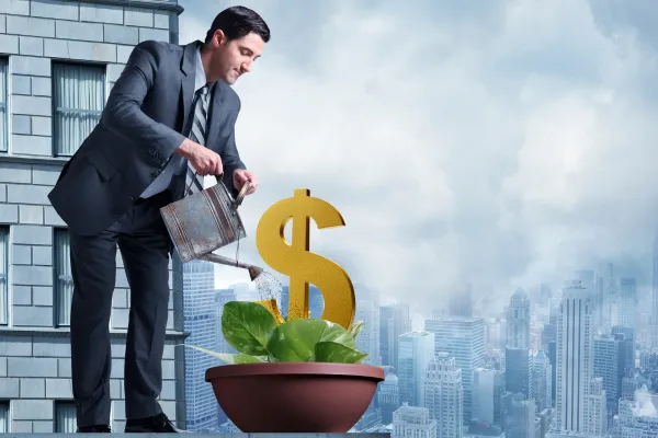 man watering a dollar sign