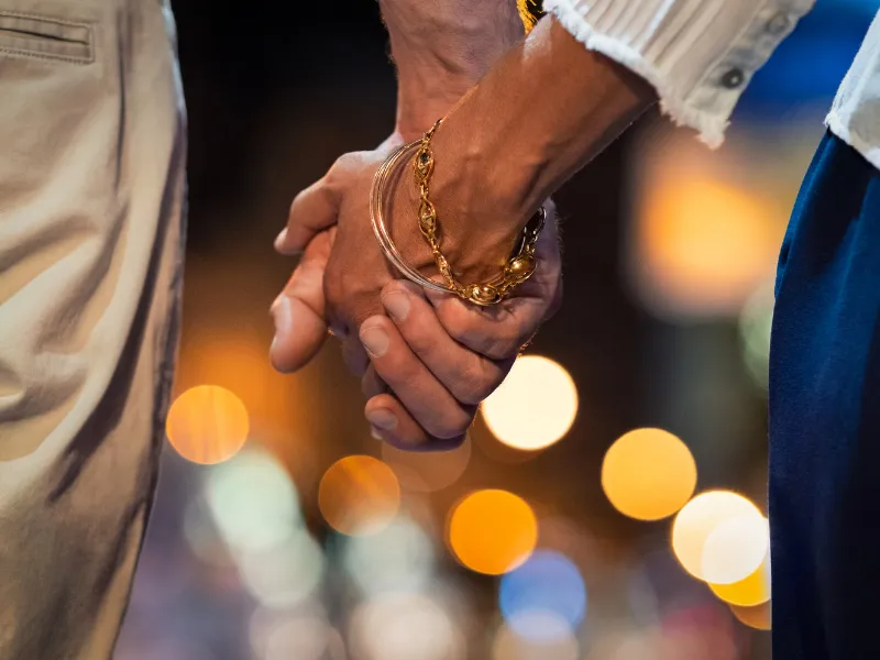 A couple holding hands outside at night