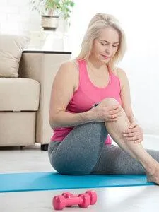 older woman yoga holding knee