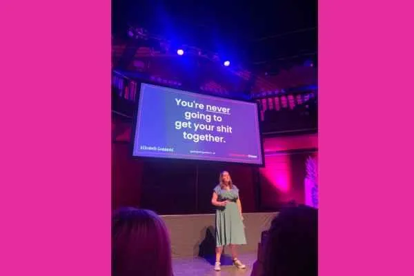 Atomicon speaker Elizabeth Goddard giving advice to small business owners with backdrop that says you're never going to get your sh1t together
