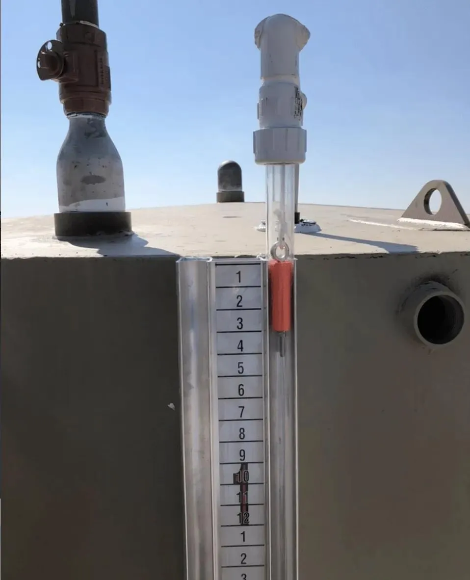 A close-up of a mechanical water tank level indicator with a red float marker, mounted on a storage tank. This design simplifies water level monitoring for industries such as agriculture, manufacturing, food processing, and water treatment.