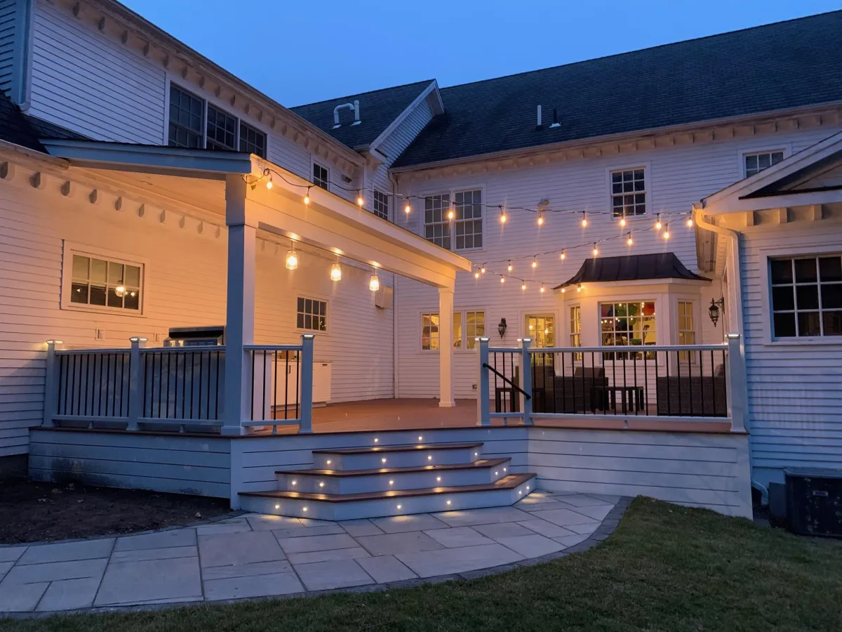 Covered deck with pergola roof and string lights at dusk - deck building by Prime Decks in Wilmington, DE