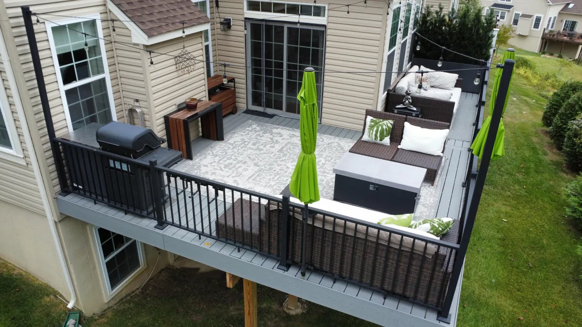 Composite deck with outdoor sofa, grill and green umbrellas - deck design by Prime Decks in Wilmington, DE