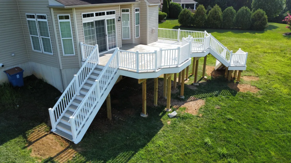 Elevated composite deck with white vinyl railings and staircase - deck design by Prime Decks in Wilmington, DE