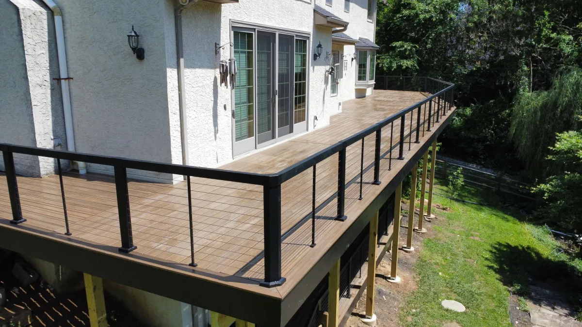 Composite deck with black cable railing on a stucco home - deck building by Prime Decks in Pike Creek, DE