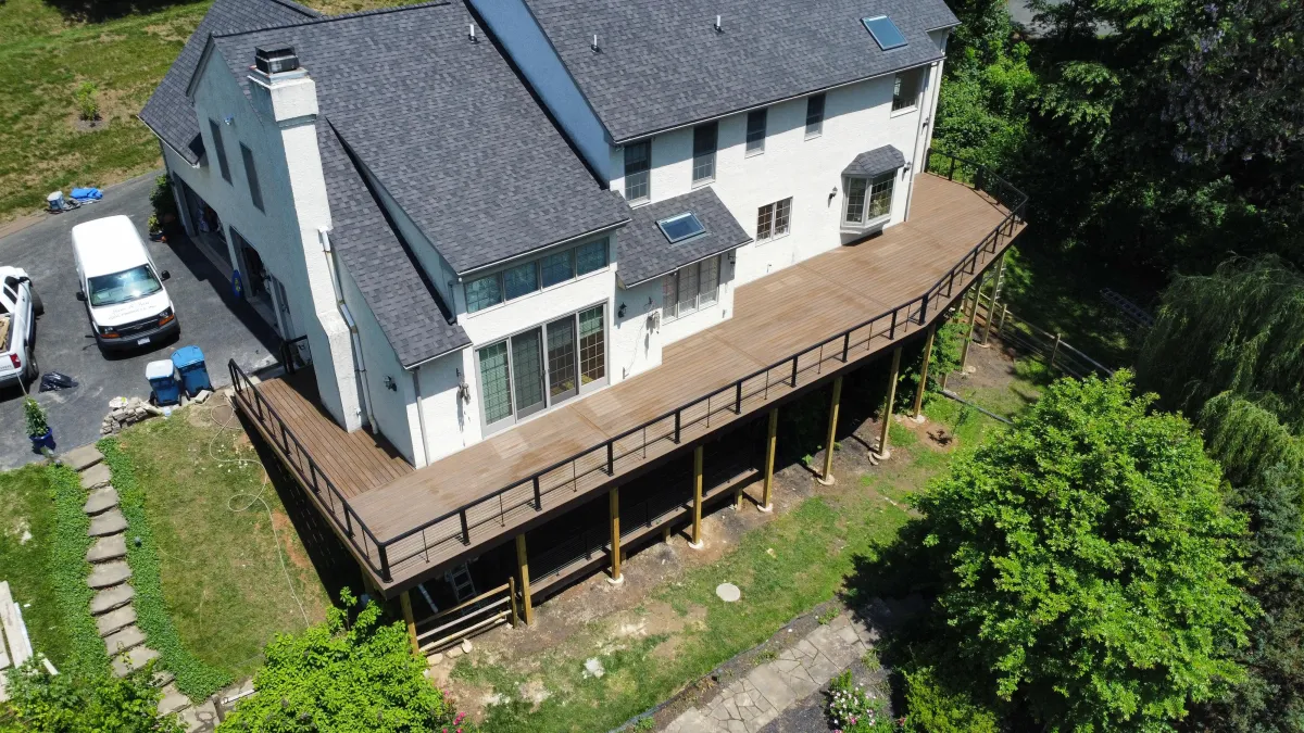 Aerial view of a long elevated wraparound deck on a two-story home - deck building by Prime Decks in Pike Creek, DE