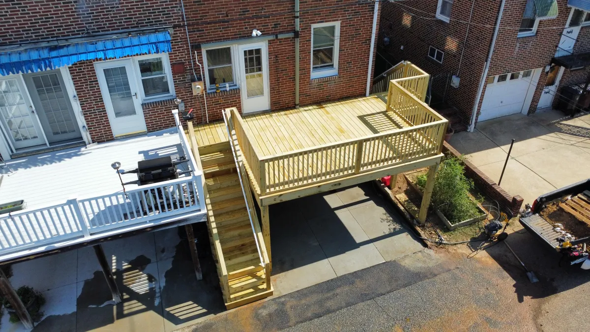 New pressure-treated wood deck with stairs on a brick home - deck building by Prime Decks in Hockessin, DE