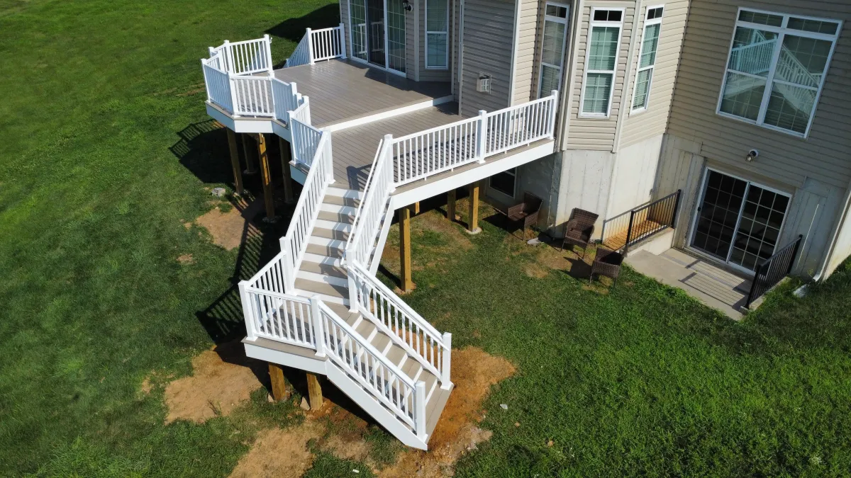 Aerial view of a raised deck with white railings and long staircase - deck building by Prime Decks in Hockessin, DE