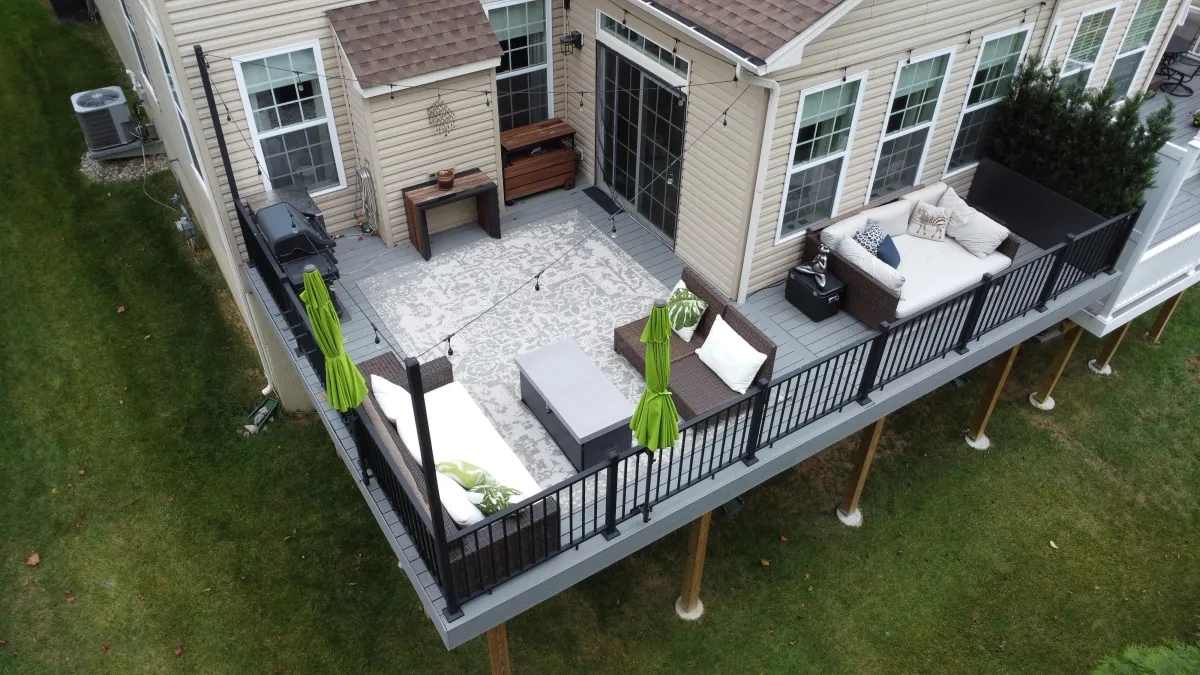 Elevated grey composite deck with black railings and outdoor lounge furniture - deck building by Prime Decks in Elsmere, DE