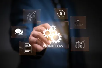 Transparent screen with man in blue suit in the background. The man is reaching out to touch the three workflow gears in the center of the screen