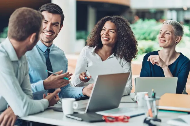 Diverse team of professionals collaborating and smiling in a positive work culture setting