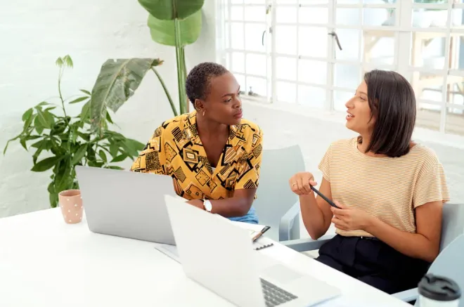 Manager and employee having a one-on-one meeting in a modern office, discussing continuous feedback as part of performance management strategy.