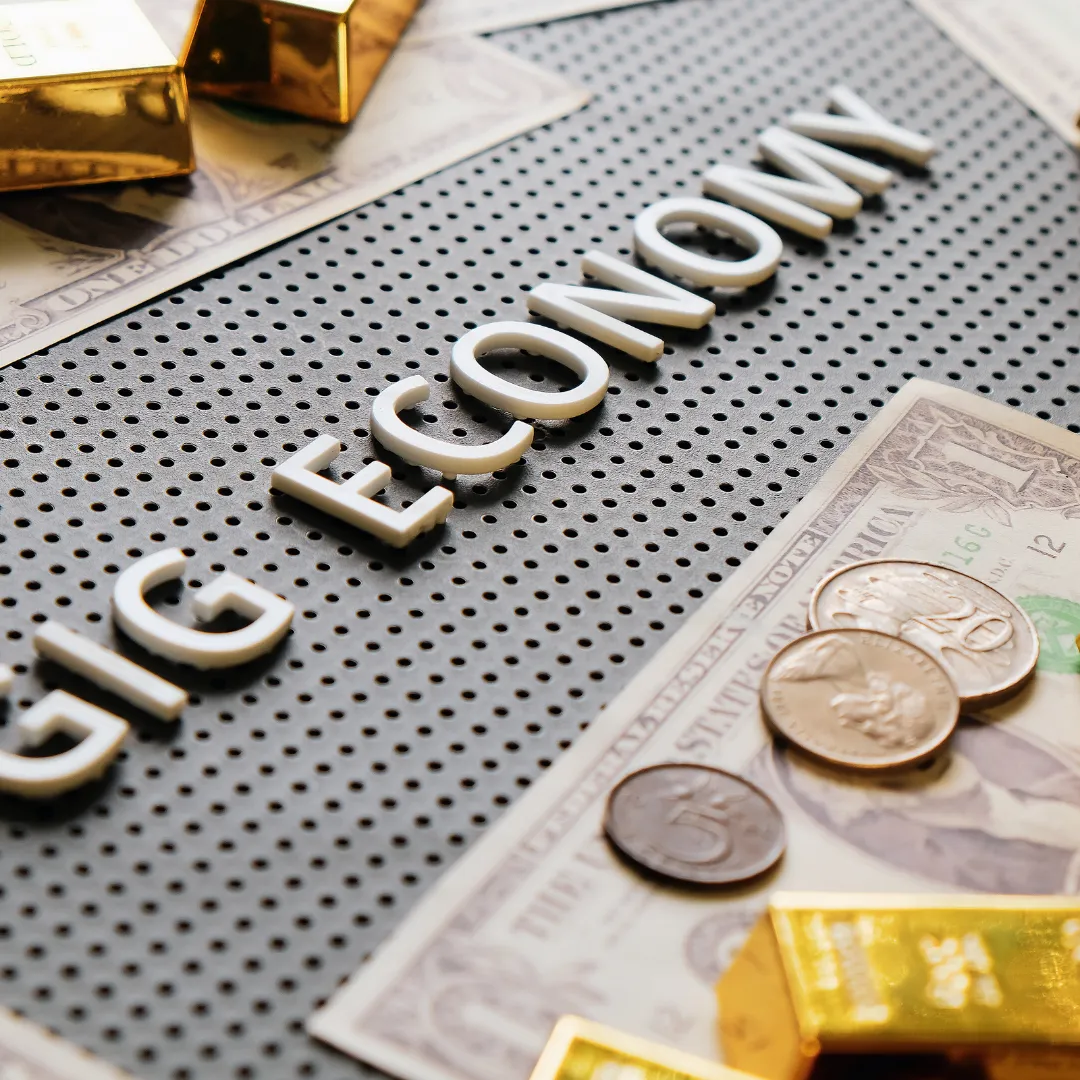 words gig economy with money laying beside it