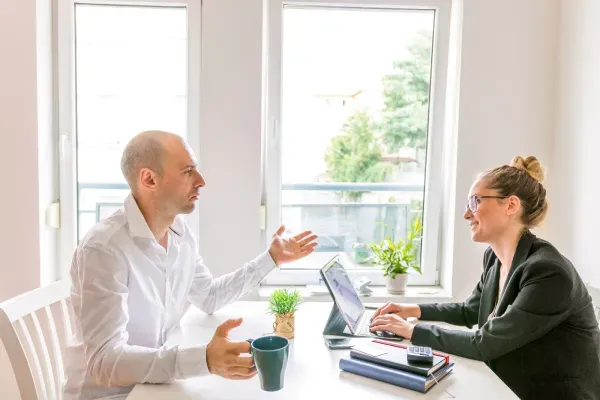 Two people making eye contact during a one-on-one meeting.