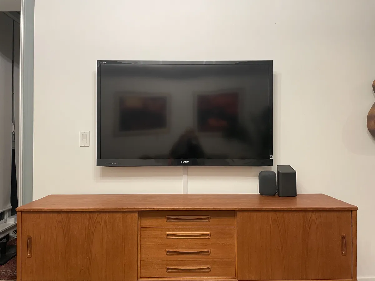 Television mounted above a stone fireplace mantel