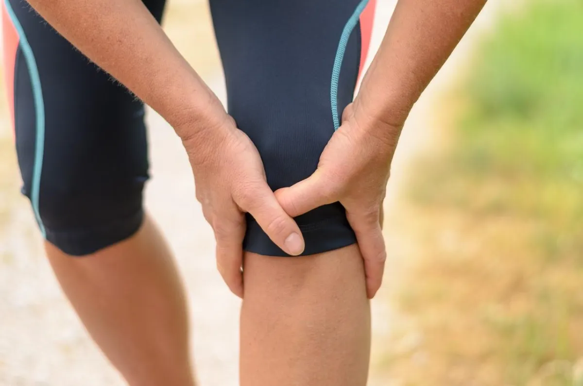 Youth athlete holding injured knee