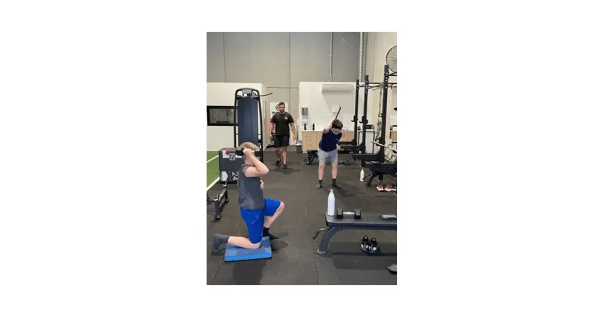 Two teenagers participating in strength training at Inner Athlete with coach
