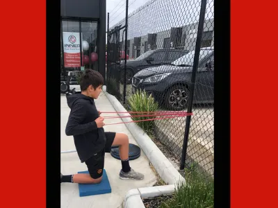 Young boy training using the band to pull tight and stretch