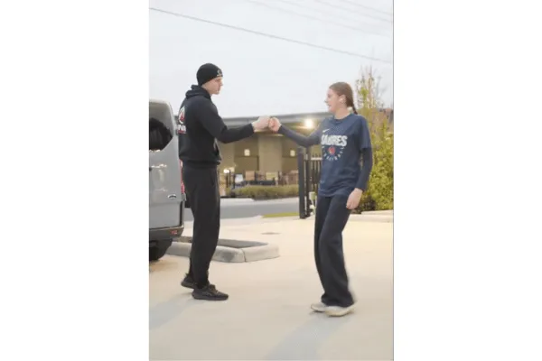 Inner Athlete coach fist pumping young female athlete in support