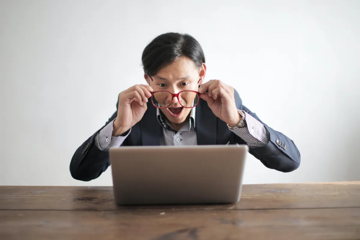 Man looking at his laptop in stunned surprise. 