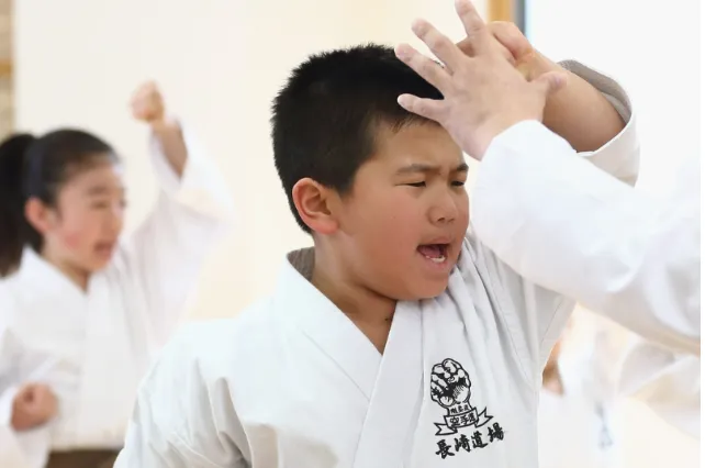 child in karate uniform performing karate