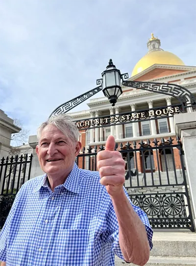 Frank Shaw gives a thumbs-up in front of the Massachusetts State House after being appointed to his third term on the Cannabis Advisory Board.