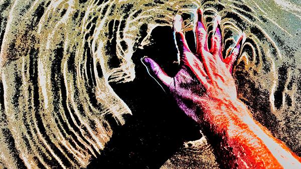 A stylized image of a hand touching rippled water, casting a shadow on the sand beneath. The bright, high-contrast colors suggest the ripple effect of impact, symbolizing influence, alignment, and connected movement.