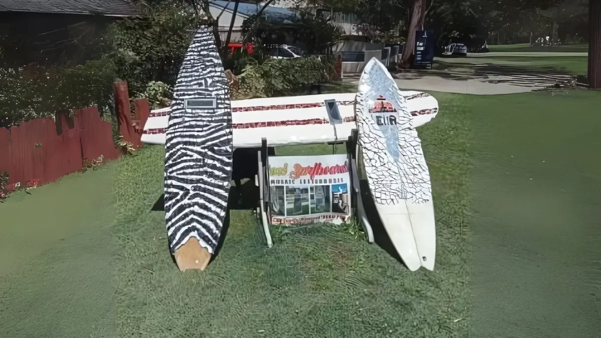 Red-and-blue mosaic surfboard letterbox featuring a Newcastle Knights logo during workshop finishing