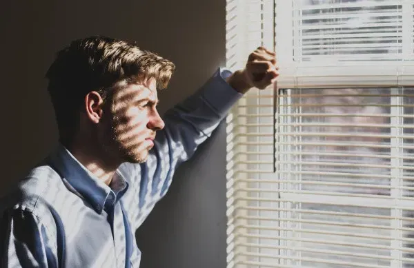 Sad man looking out window