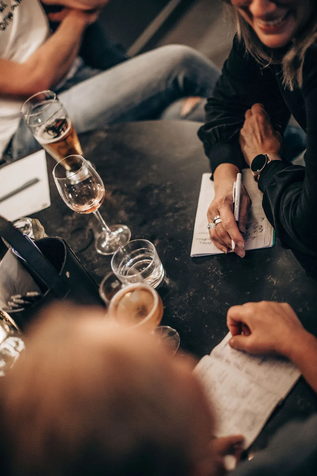 Vänner antecknar ledtrådar vid ett bord med vin och öl