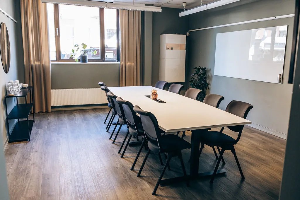 Mötesrum med långbord för styrelsesittning och whiteboard