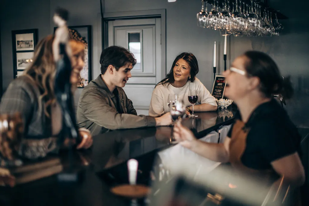 Gäster skålar i vin vid baren i vinbaren